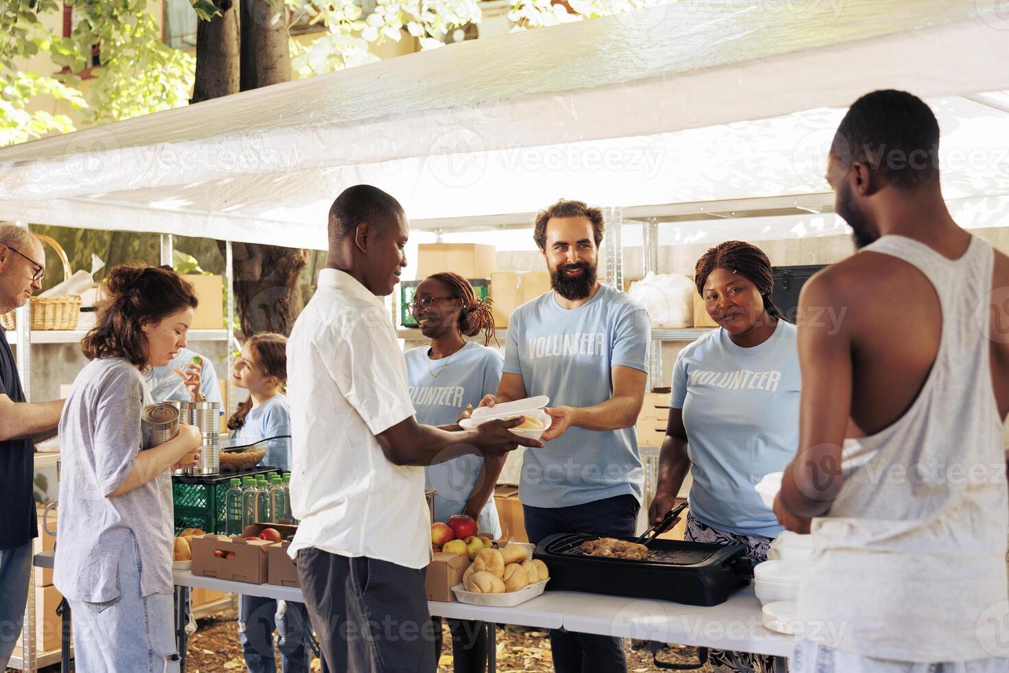 Assisting the needy, compassionate volunteers distribute essential items at a homeless center. Non-porift hunger relief team provide free food, support, and donations to the poor and less privileged. photo