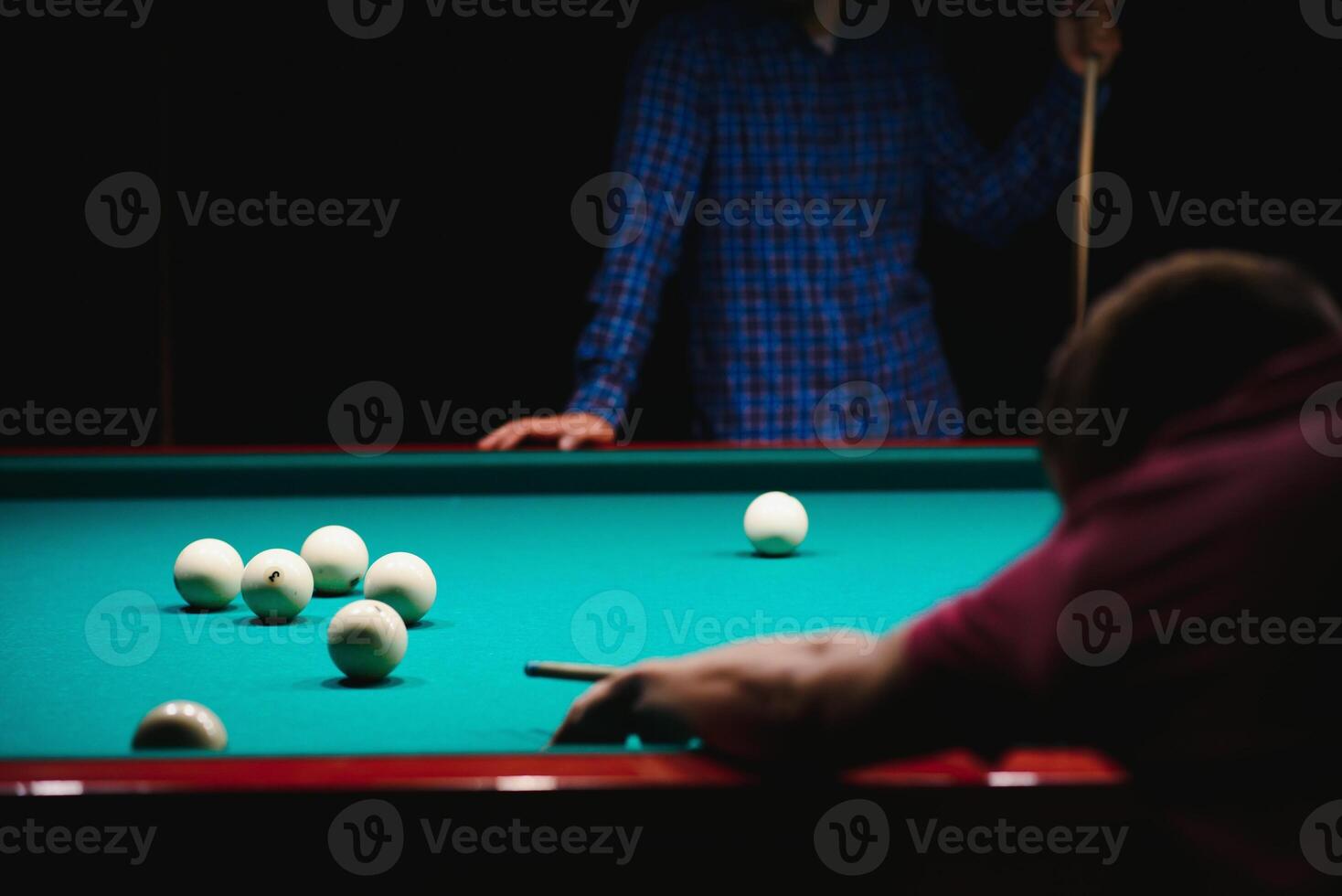 the player takes aim at the ball in Billiards photo
