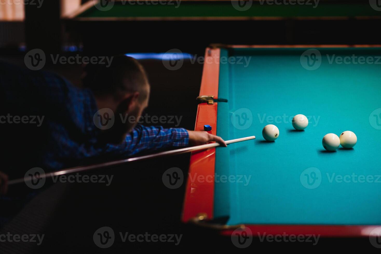 the player takes aim at the ball in Billiards photo