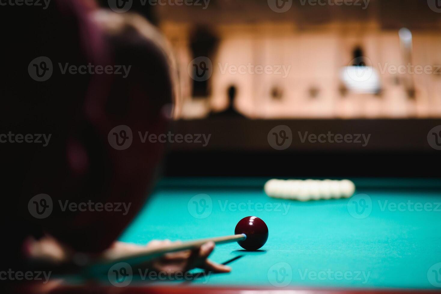 the player takes aim at the ball in Billiards photo