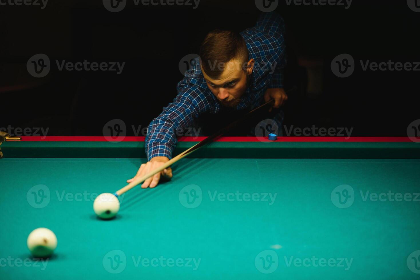 the player takes aim at the ball in Billiards photo