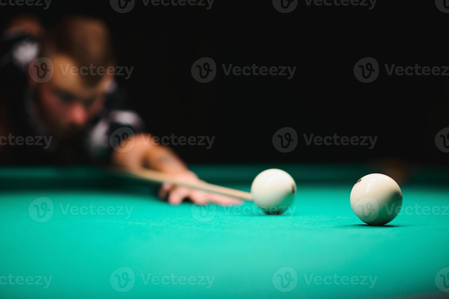 the player takes aim at the ball in Billiards photo