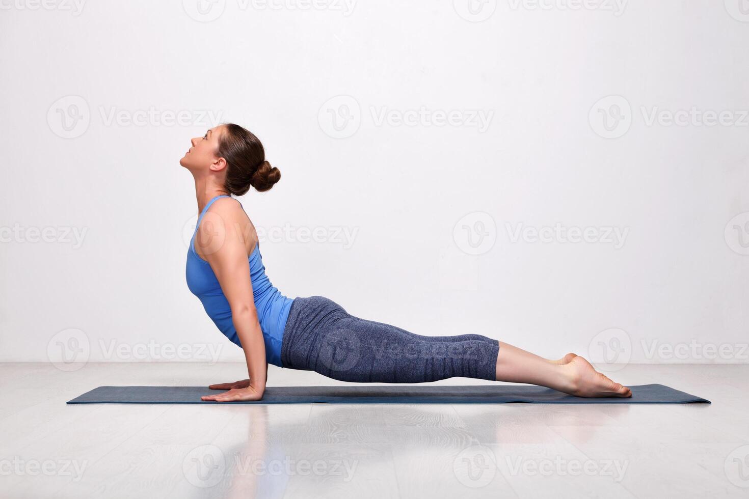 Sporty fit yogini woman practices yoga asana Urdhva mukha svanas photo