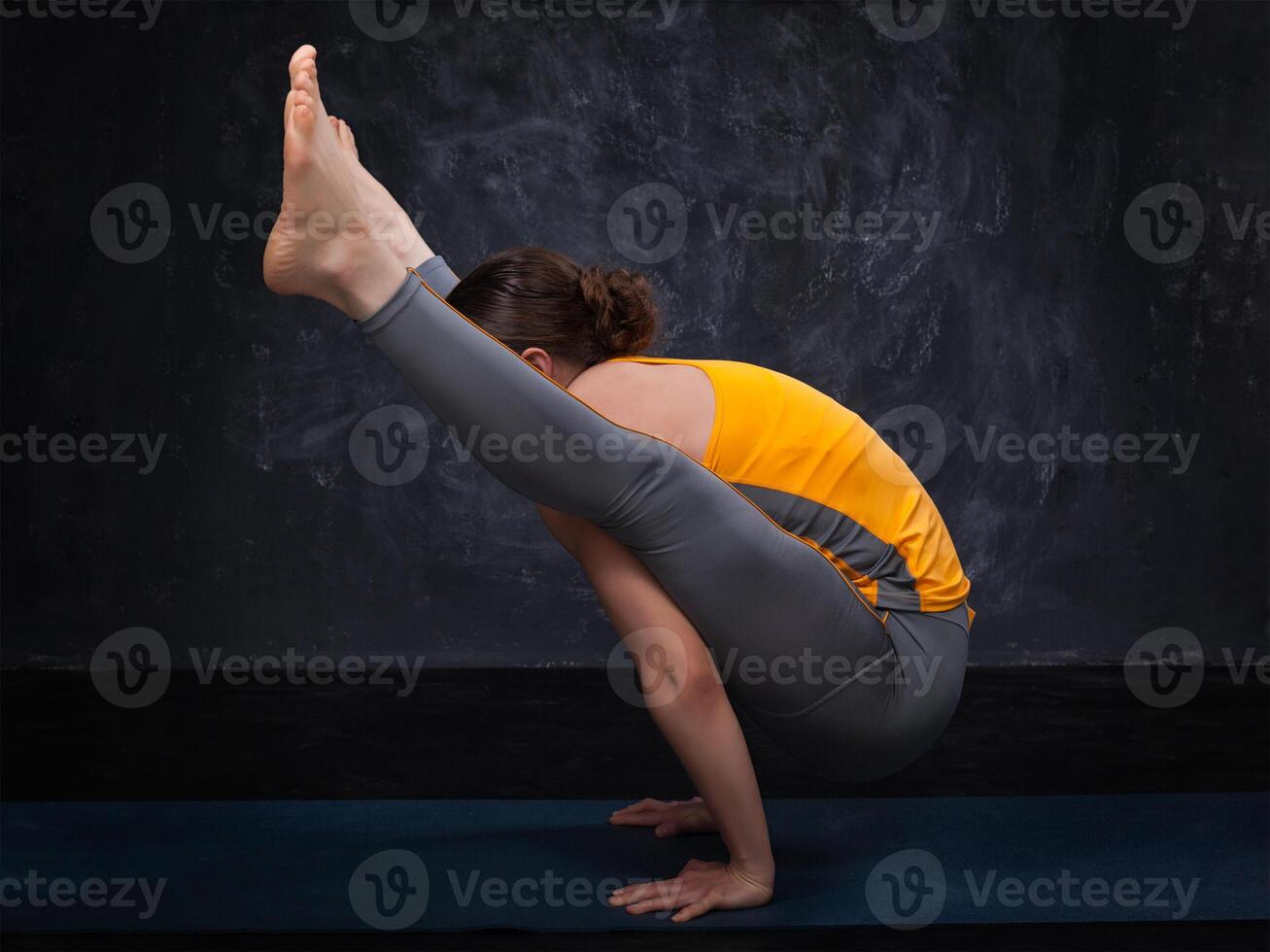 Beautiful sporty fit yogi girl practices yoga asana titibhasana photo