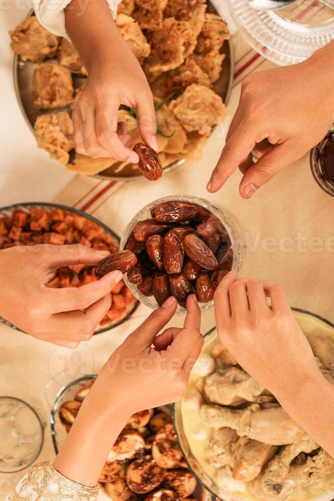 Hands Take Dates Fruit or Kurma, Concept Buka Bersama, Sharing Food during Ramadan Fasting Month photo