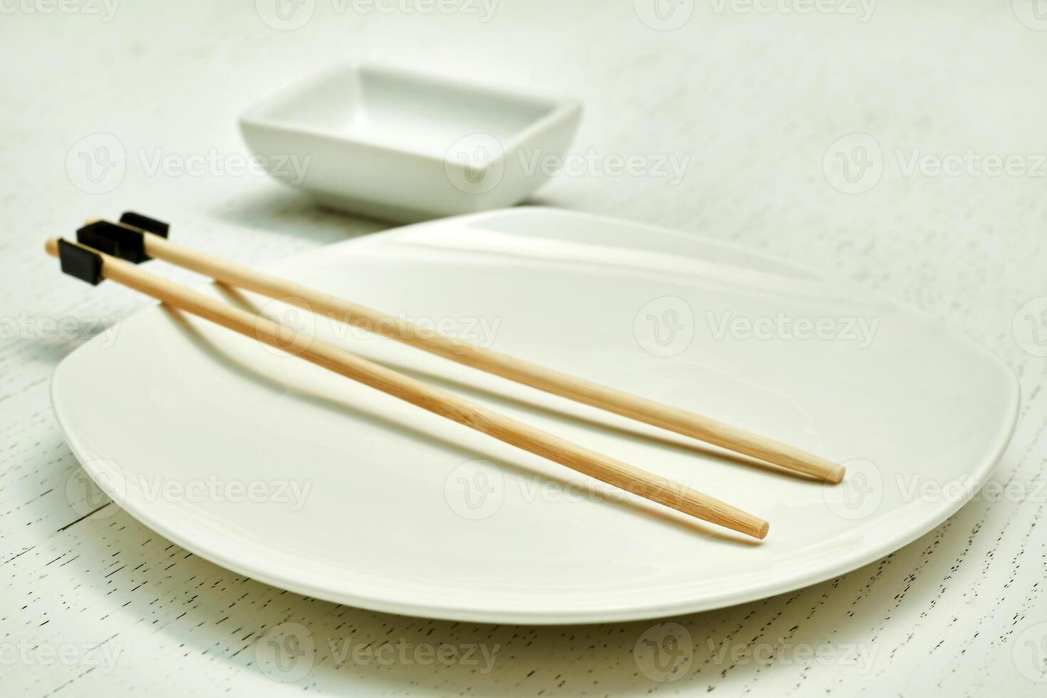Wooden chopsticks for the inept. Oriental food, sushi, plate, gravy bowl photo