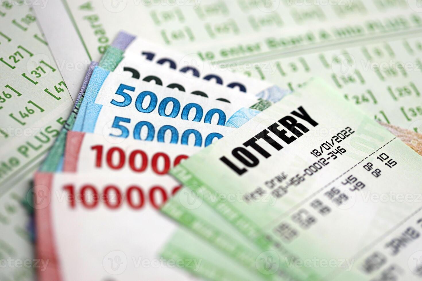 Green lottery tickets and indonesian money bills on blank with numbers for playing lottery photo