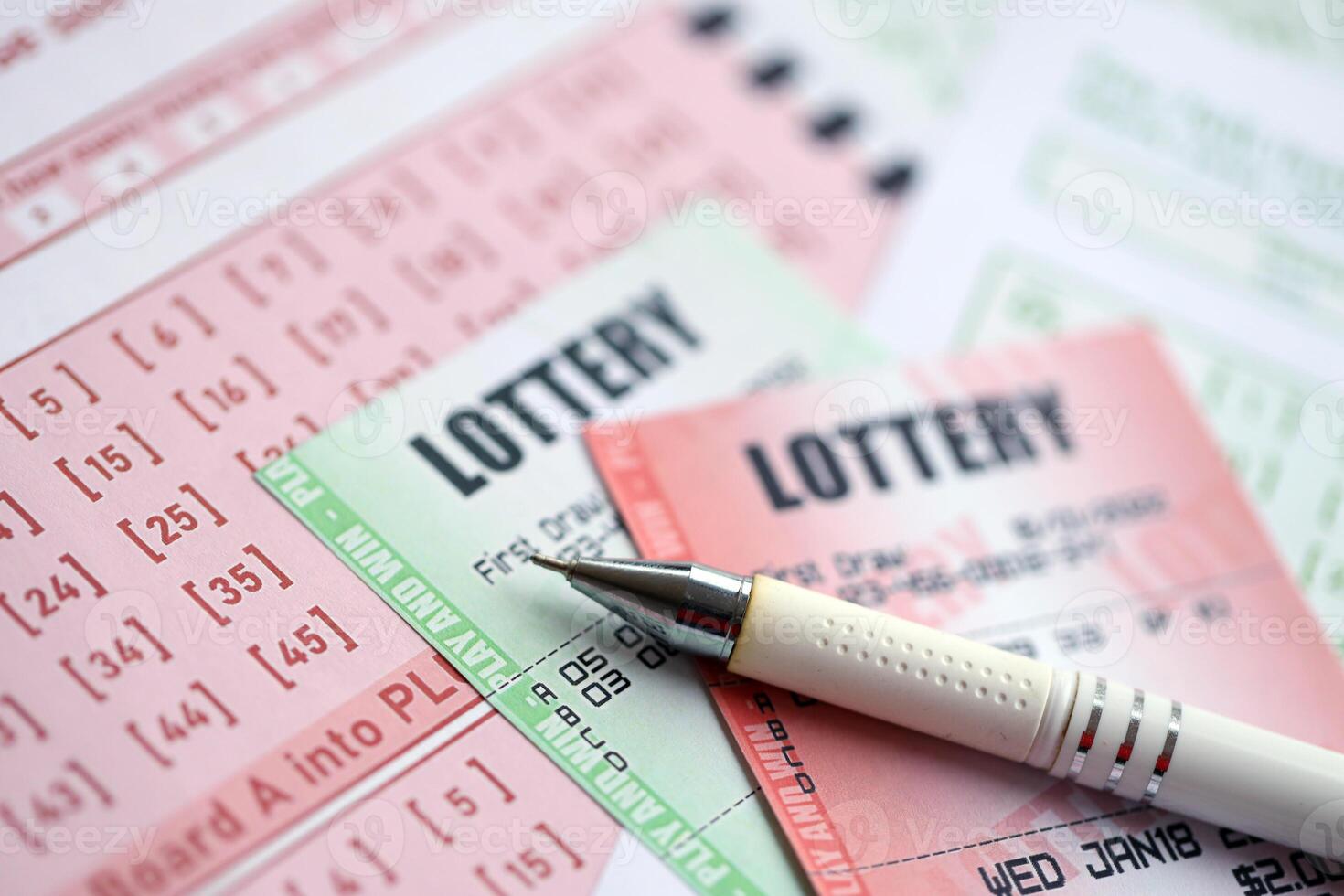 Green and red lottery tickets with pen on blank bills with numbers for playing lottery photo