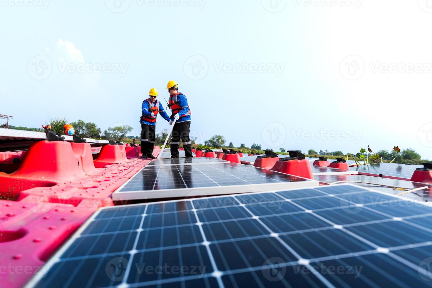 Photovoltaic engineers work on floating photovoltaics. workers Inspect and repair the solar panel equipment floating on water. Engineer working setup Floating solar panels Platform system on the lake. photo
