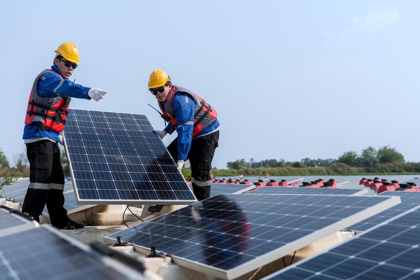 fotovoltaica ingenieros trabajo en flotante fotovoltaica. trabajadores inspeccionar y reparar el solar panel equipo flotante en agua. ingeniero trabajando preparar flotante solar paneles plataforma sistema en el lago. foto