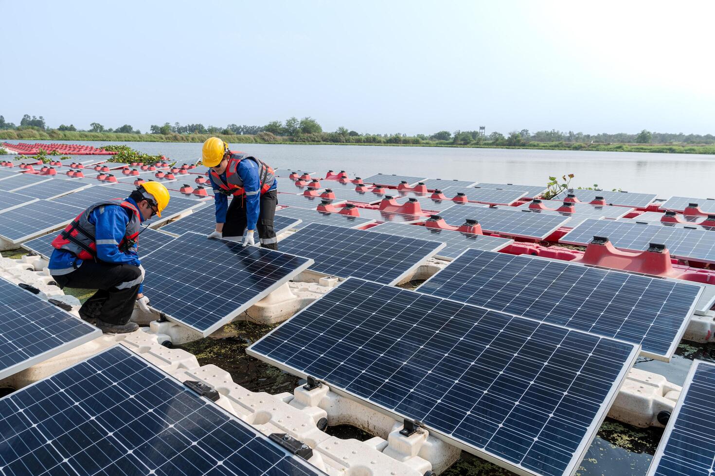 fotovoltaica ingenieros trabajo en flotante fotovoltaica. trabajadores inspeccionar y reparar el solar panel equipo flotante en agua. ingeniero trabajando preparar flotante solar paneles plataforma sistema en el lago. foto