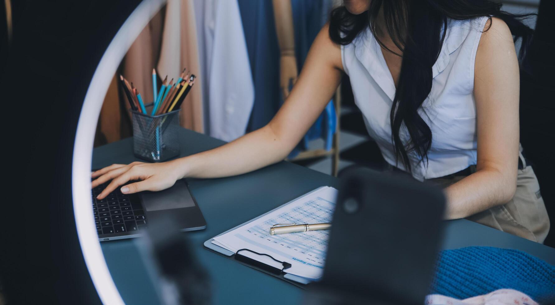 Beautiful asian woman blogger showing bag in front of camera to recording vlog video live streaming at her shop.Business online influencer on social media concept. photo