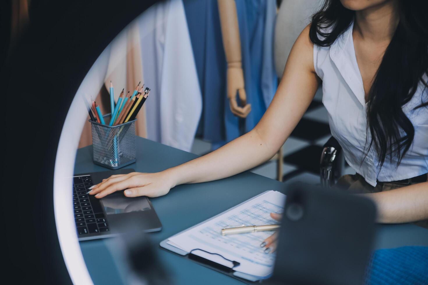 Beautiful asian woman blogger showing bag in front of camera to recording vlog video live streaming at her shop.Business online influencer on social media concept. photo