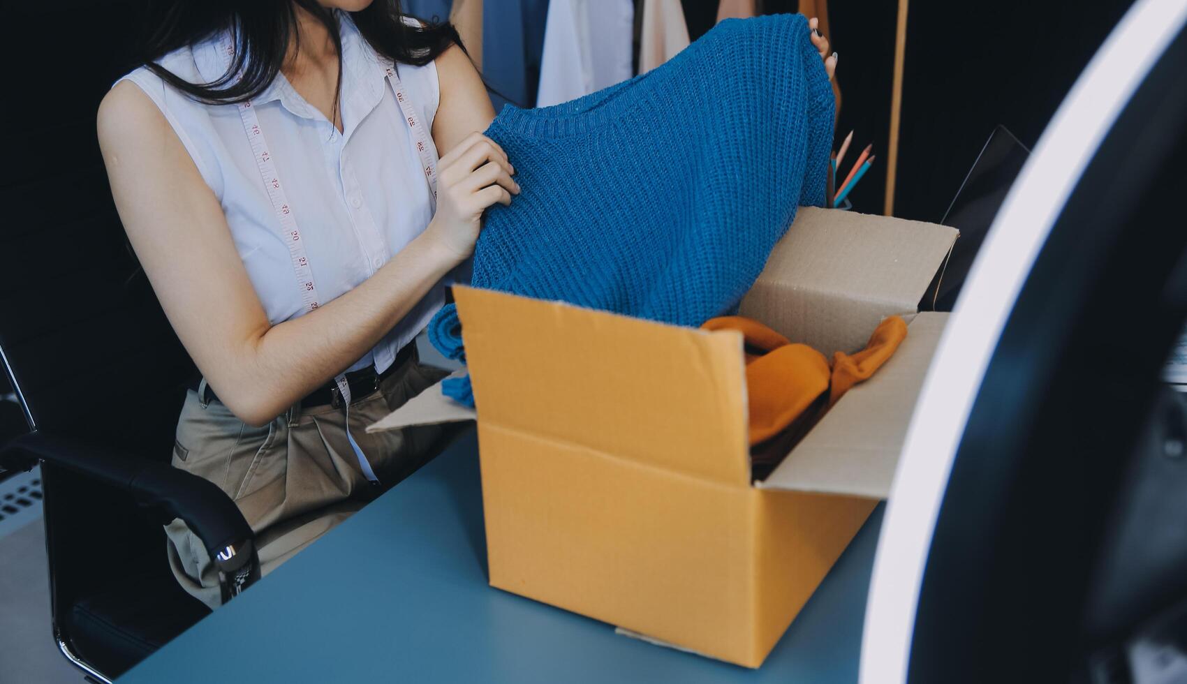 Beautiful asian woman blogger showing bag in front of camera to recording vlog video live streaming at her shop.Business online influencer on social media concept. photo