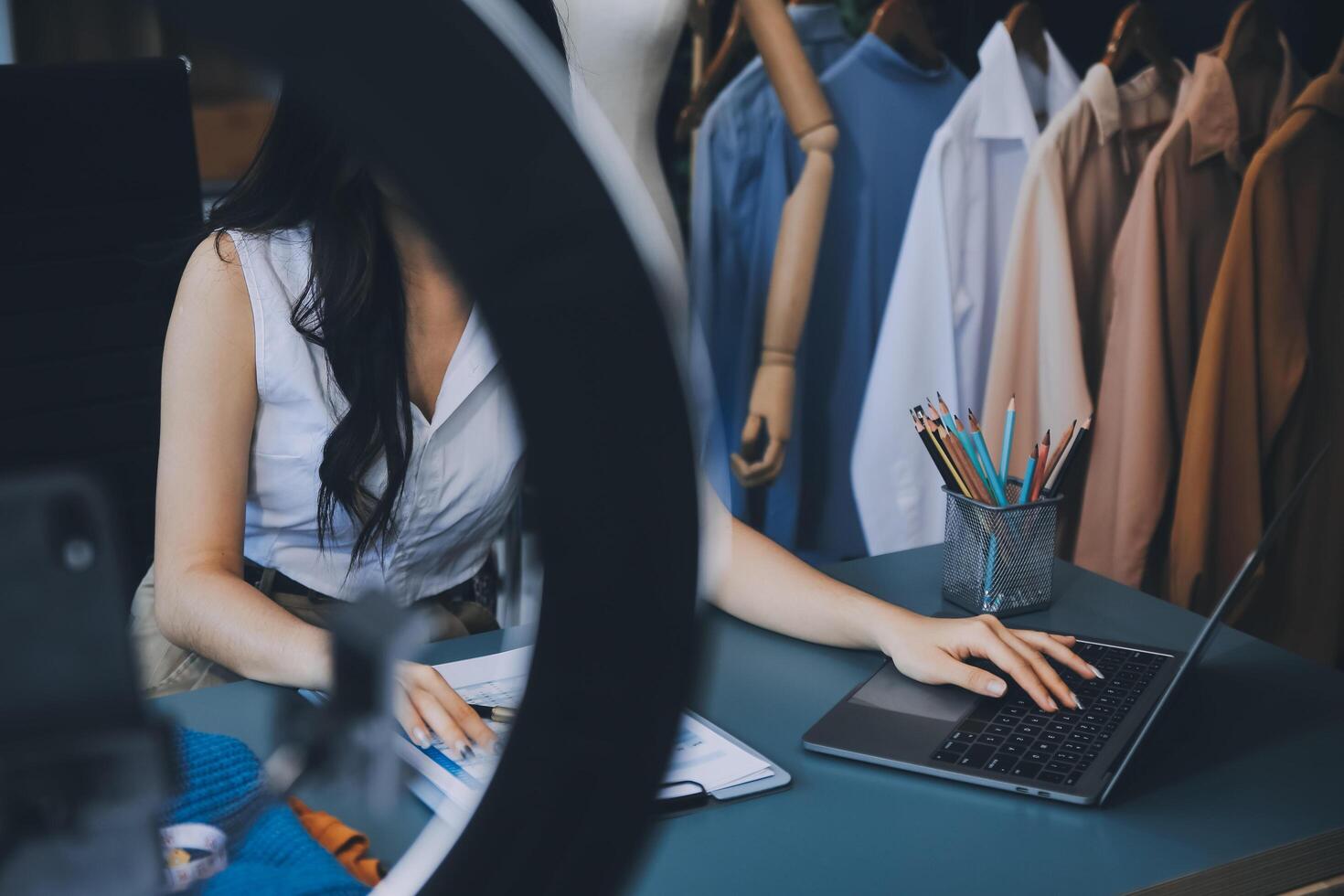 Beautiful asian woman blogger showing bag in front of camera to recording vlog video live streaming at her shop.Business online influencer on social media concept. photo