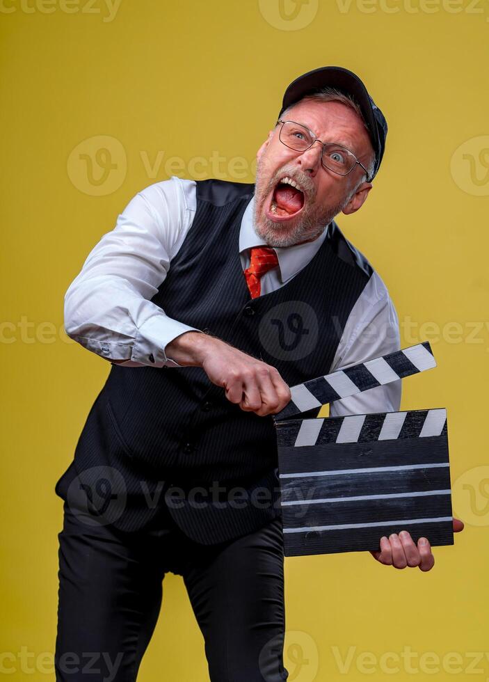 hombre sostiene película solapa. masculino en gorra con abierto boca. película dirigente. película producción. humano emociones cerca arriba. foto