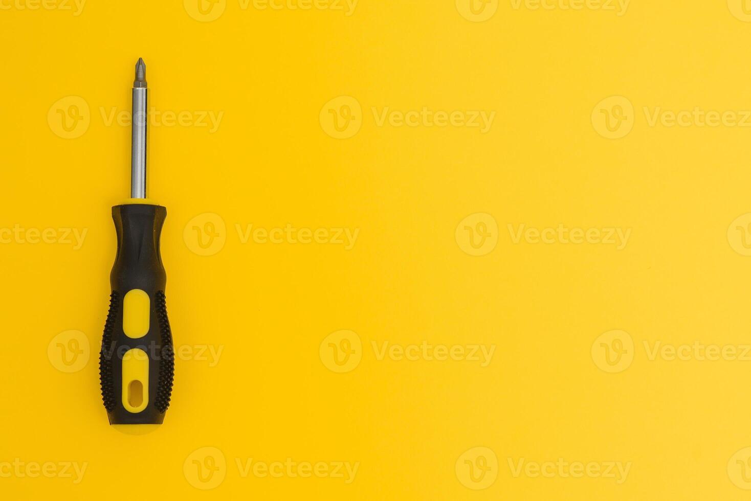 black and yellow screwdriveron a yellow background with space for text. Tools, construction and workshop, home repairs, slusar work photo