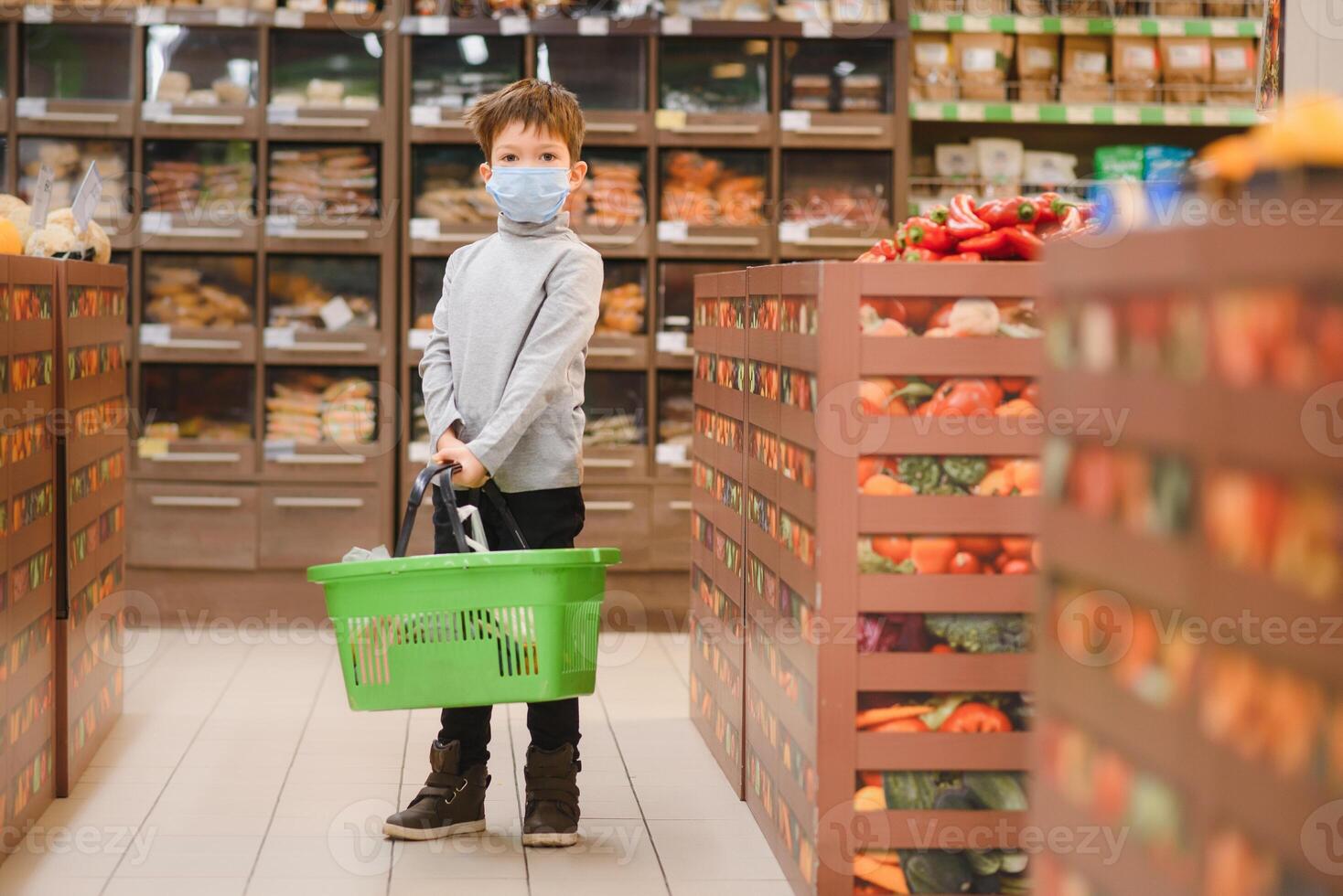 Boy wears protected mask in store. Shopping time during coronavirus outbreak.Boy in a medical mask. Quarantine and protection virus, flu, epidemic COVID-19. Coronavirus quarantine photo