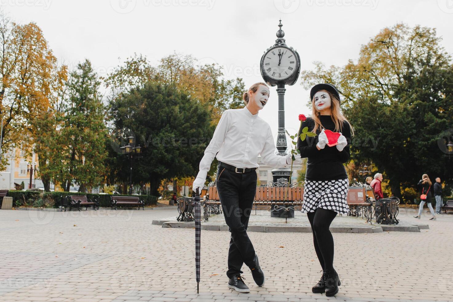 A couple of merry mimes. He hurries on a date. photo