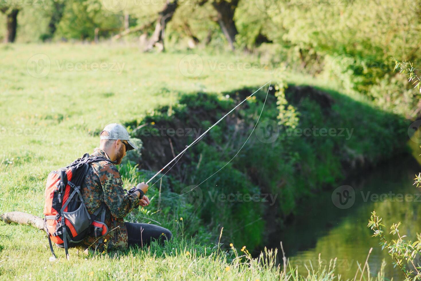 hombre relajante y pescar por junto al lago fines de semana hecho para pesca. pescador masculino pasatiempo. Maestro cebo. mantener calma y pescado en. pescador tejido a ganchillo girar dentro el río esperando grande pez. chico mosca pescar foto