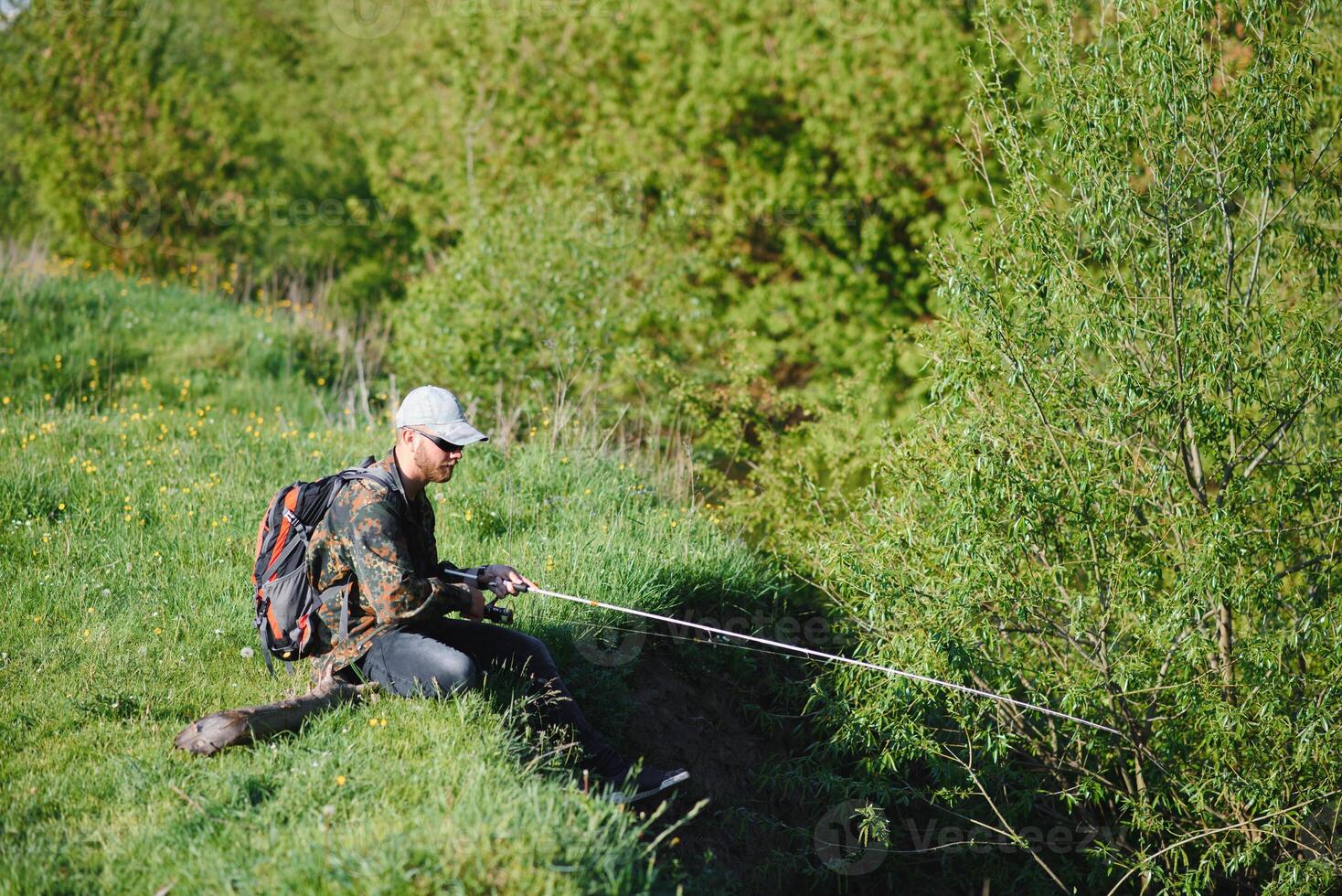 hombre relajante y pescar por junto al lago fines de semana hecho para pesca. pescador masculino pasatiempo. Maestro cebo. mantener calma y pescado en. pescador tejido a ganchillo girar dentro el río esperando grande pez. chico mosca pescar foto