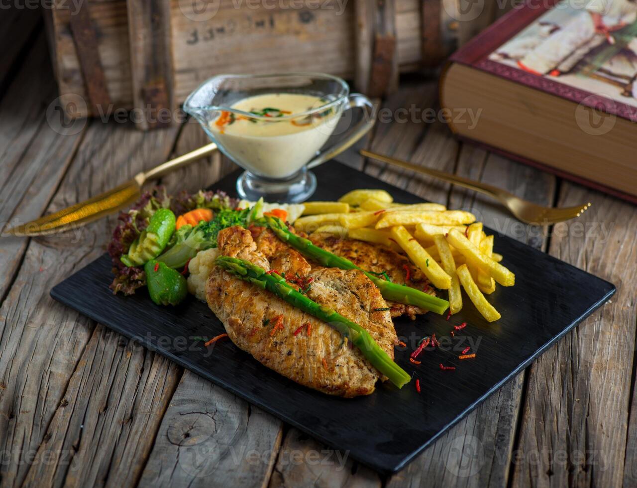 chicken steak with fries isolated on cutting board on wooden background side view of steak photo