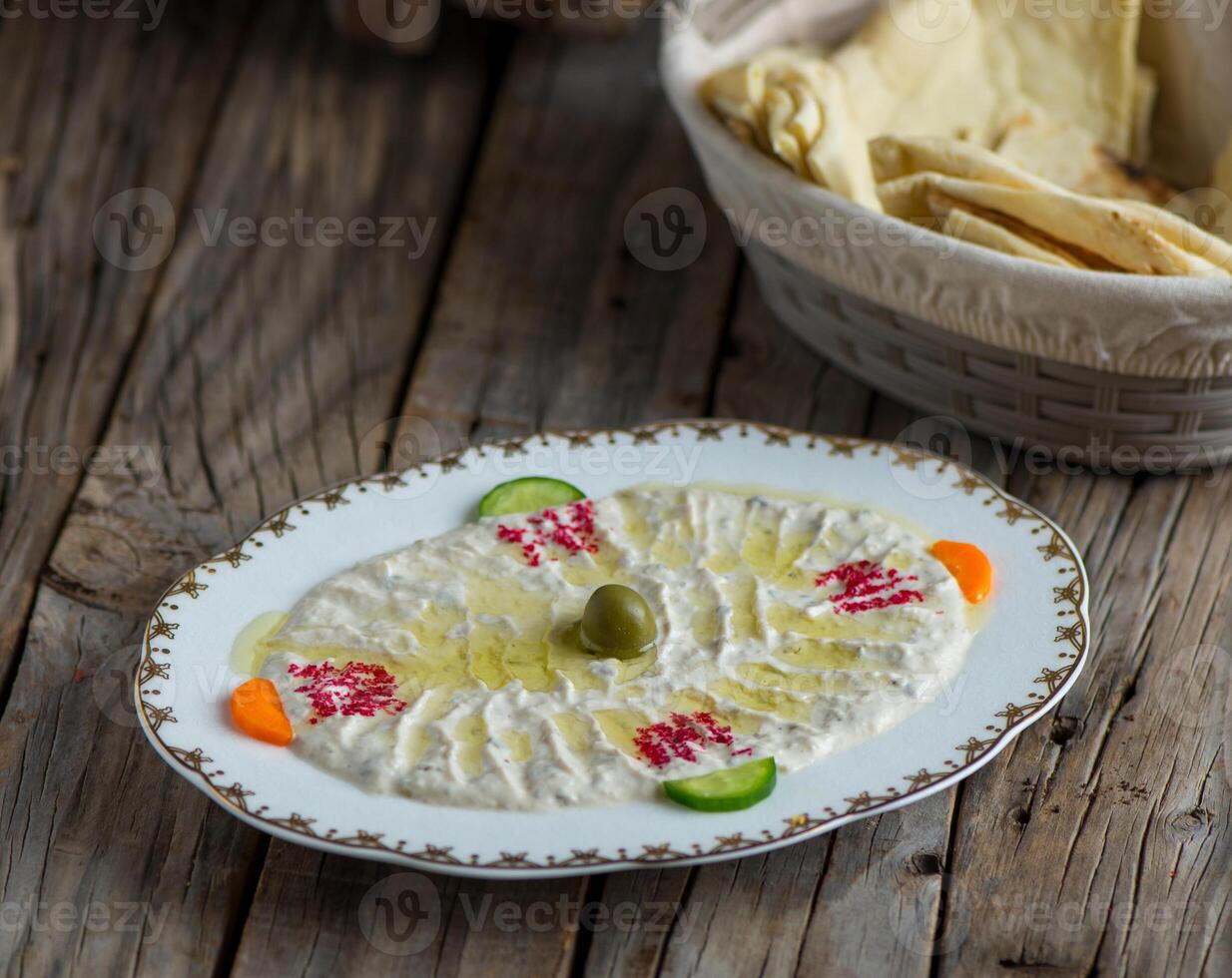moutable hummus served in a dish isolated on wooden background side view of appetizer photo