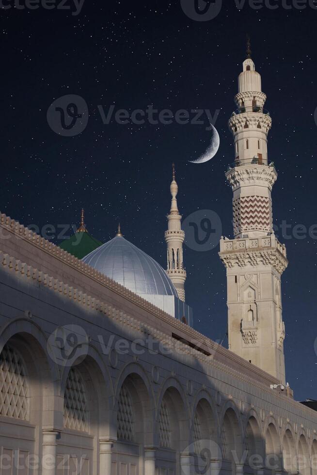 A mosque with the full moon in the sky. Masjid nabi of Medina, mosque at night. Masjid nabi of Medina. Green dome and moon.. photo