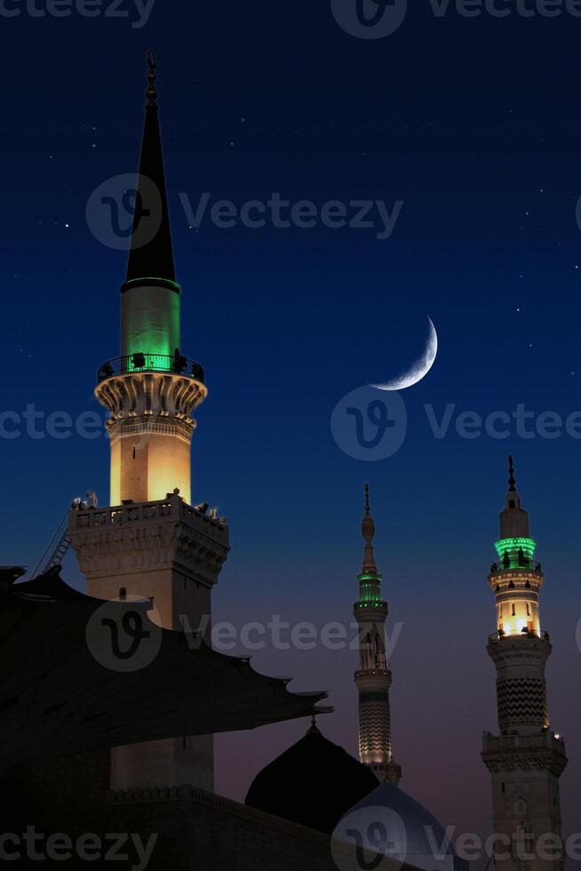 A mosque with the full moon in the sky. Masjid nabi of Medina, mosque at night. Masjid nabi of Medina. Green dome and moon.. photo