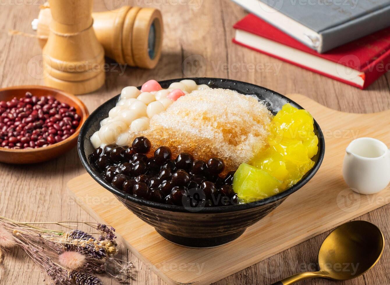 Shaved Ice with mango, red beans and rice ball served in bowl isolated on table top view of asian food photo