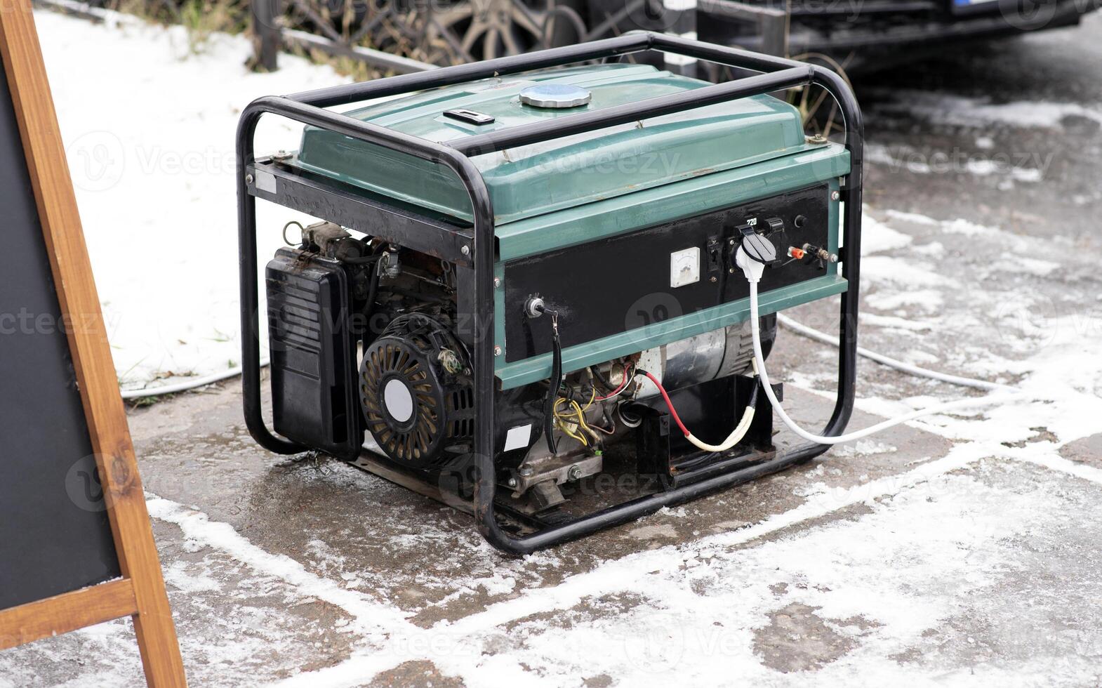 Portable electric generator running in the cold winter.Energy genocide. Power outage as a result of missile strikes by Russia on energy facilities of Ukraine. Small business use gasoline generators. photo