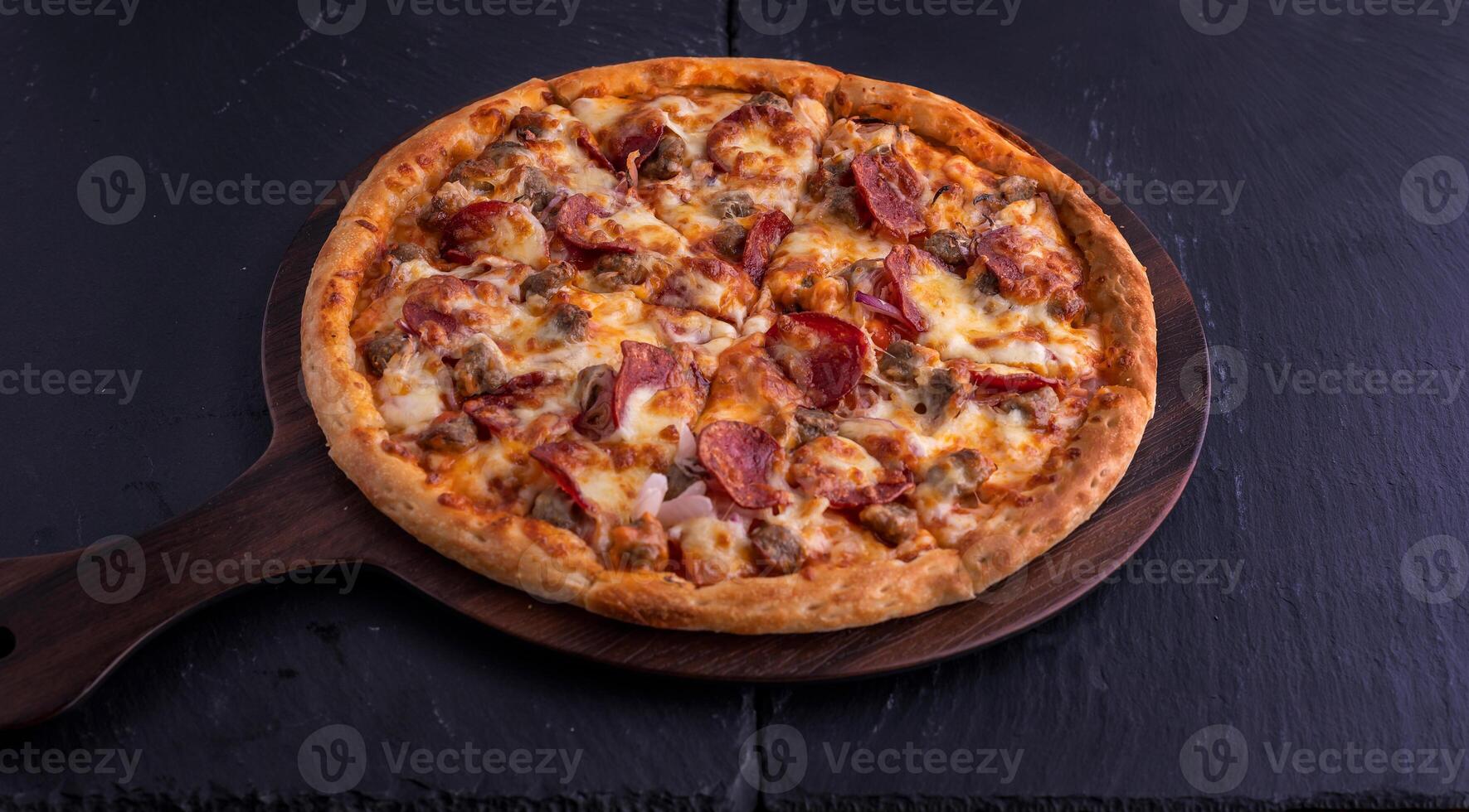 Hot meat pizza isolated on cutting board top view on dark background italian fast food photo