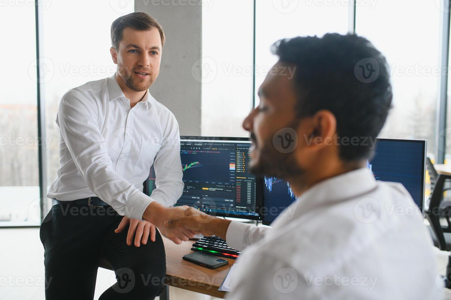 dos hombres comerciantes sentado a escritorio a oficina juntos supervisión cepo datos vela cartas en pantalla analizando precio fluir sonriente alegre teniendo lucro trabajo en equipo concepto foto