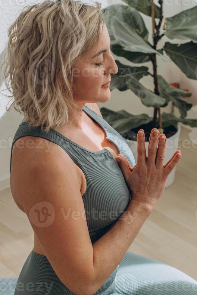 un 50 años mujer lo hace yoga a hogar foto