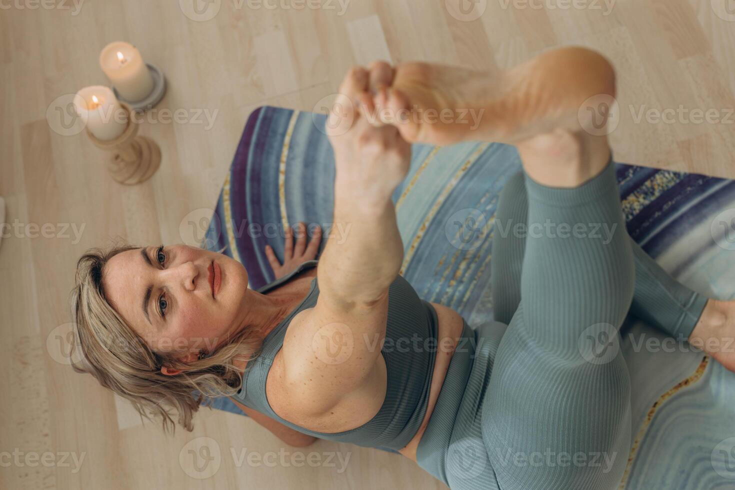 A 50-year-old woman does yoga at home photo