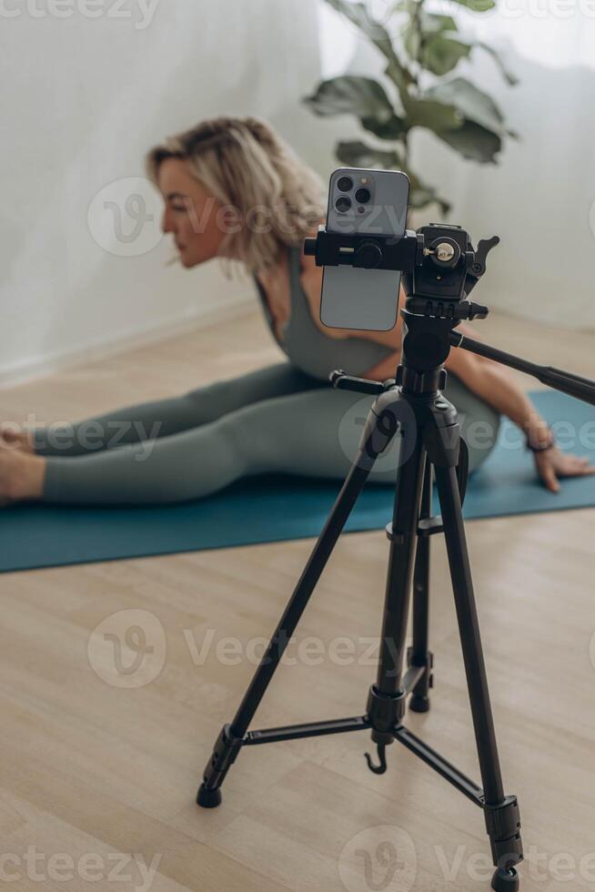 un 50 años mujer haciendo en línea yoga a hogar foto