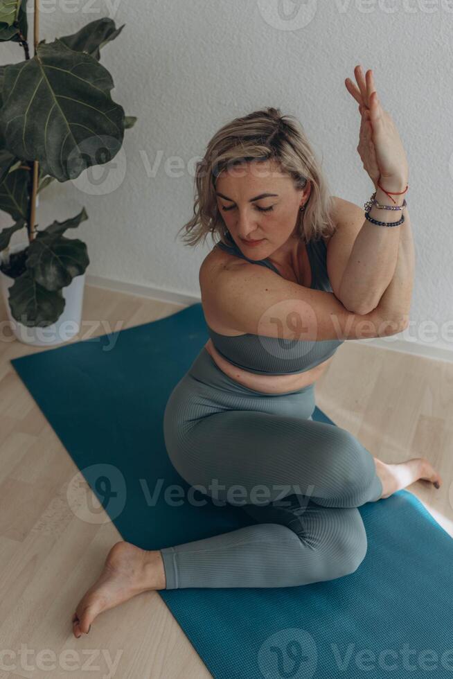 un 50 años mujer lo hace yoga a hogar foto