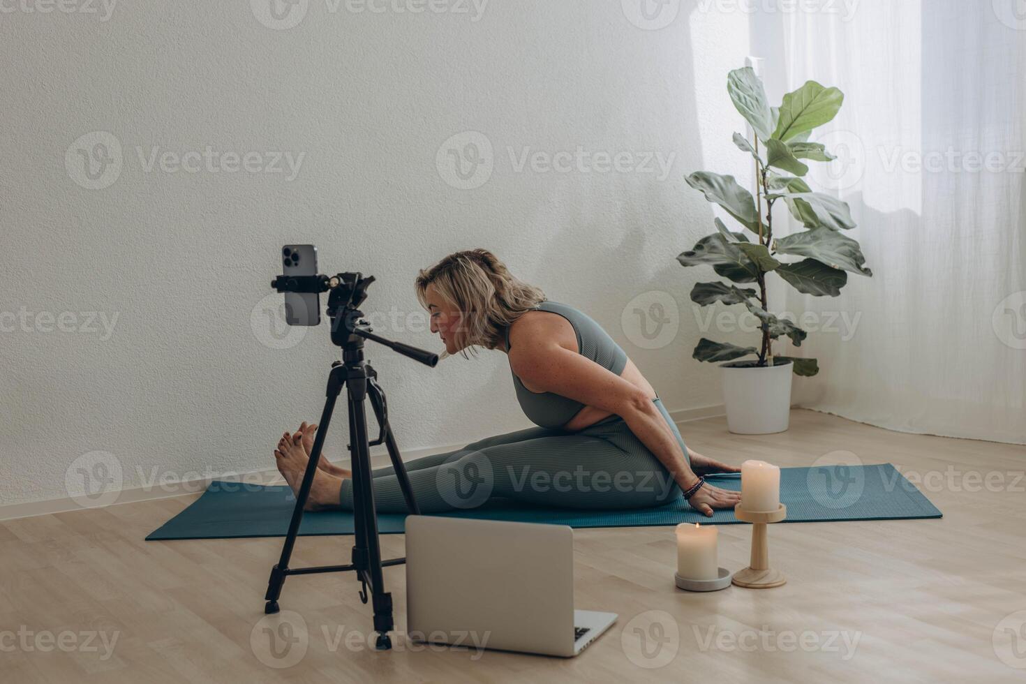 A 50-year-old woman doing online yoga at home photo