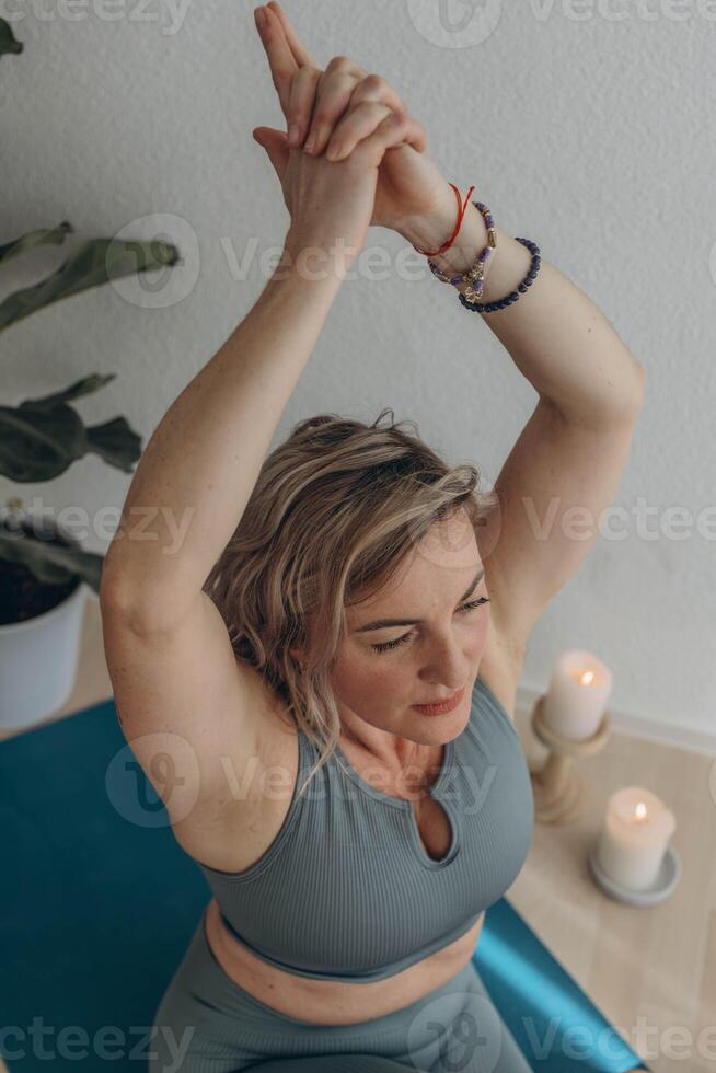 A 50-year-old woman does yoga at home photo