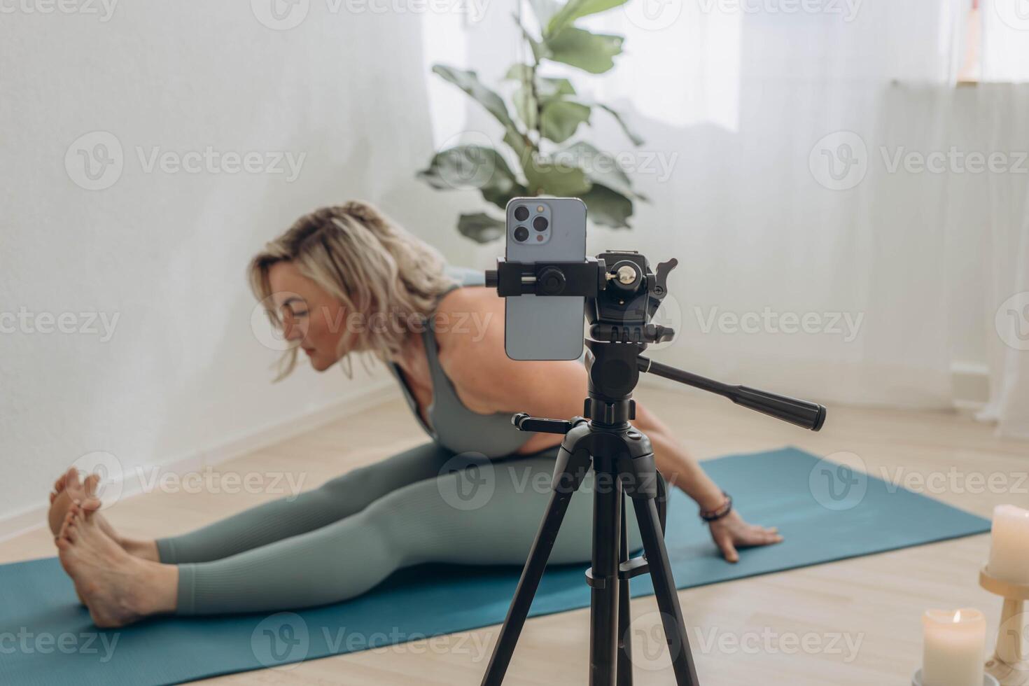 A 50-year-old woman doing online yoga at home photo