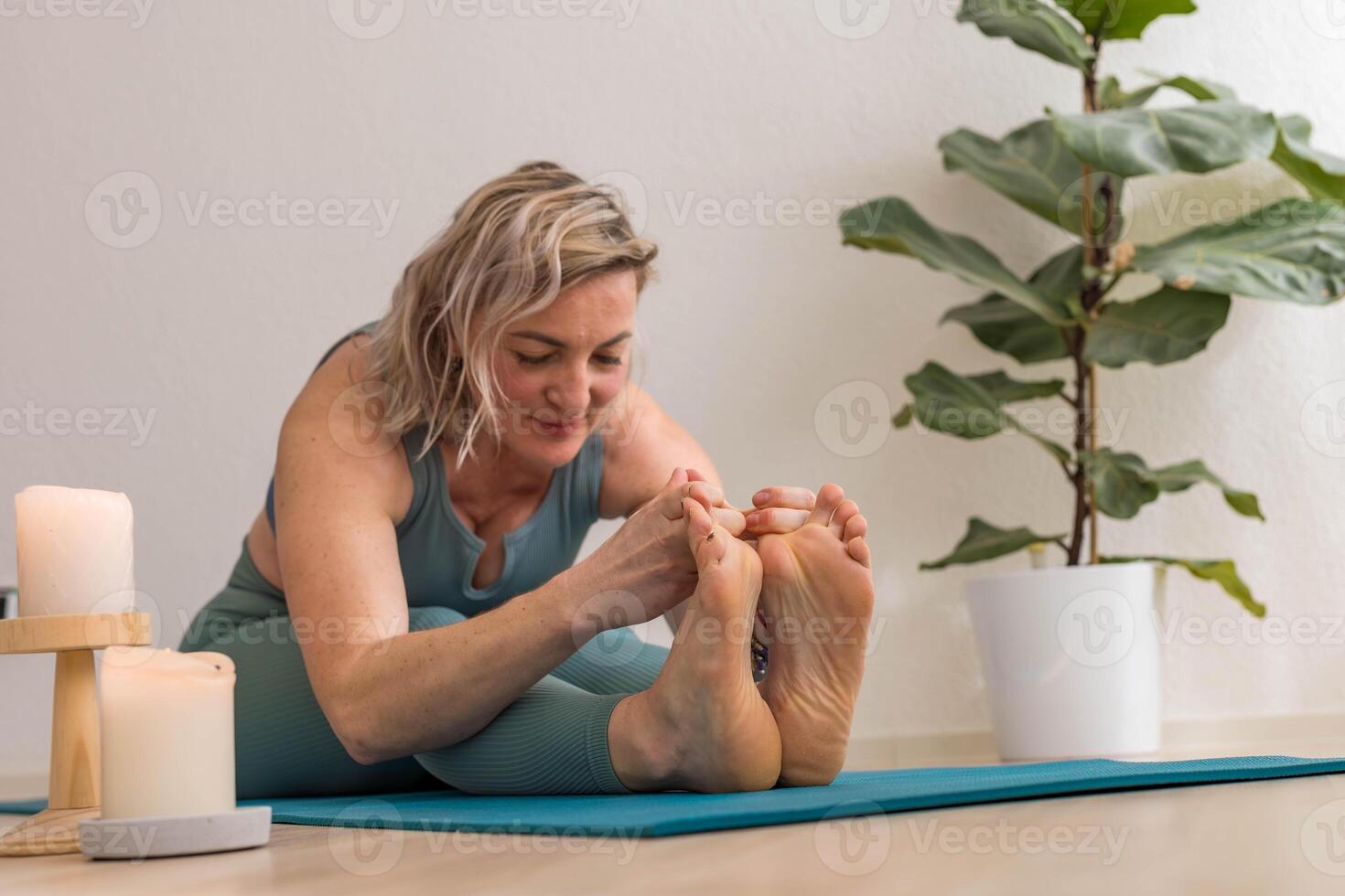 A 50-year-old woman does yoga at home photo