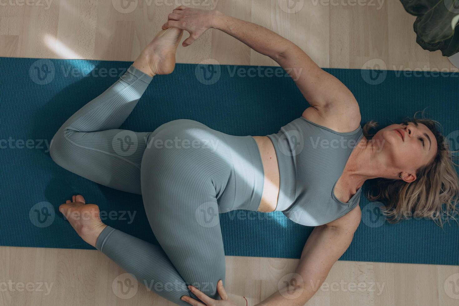 A 50-year-old woman does yoga at home photo