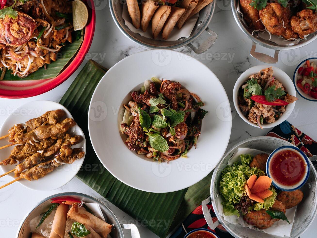 selective choice food table Shell Crab noodle , Chicken Satay, Spring Roll, Curry Samosa, fish cake, Folks Drumlet, Pork Jar Salad in a dish isolated on mat top view on grey marble background photo