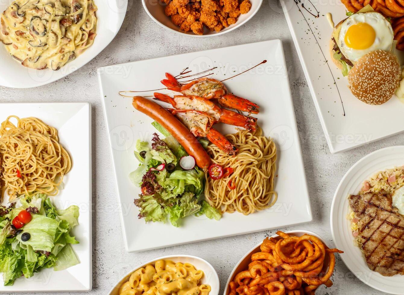 grilled tiger prawn, sausage, aglio pasta, pork chop, fried rice, shiok beef burger, bacon, mushroom carbonara spaghetti, pop corn chicken, fries, mac n cheese served top view italian food variety photo