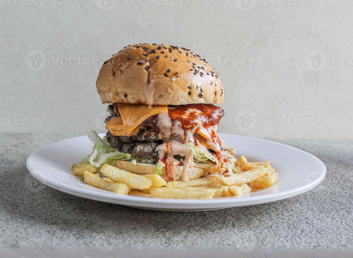 Double beef cheese burger with fries served in a dish isolated on grey background side view of fast food photo