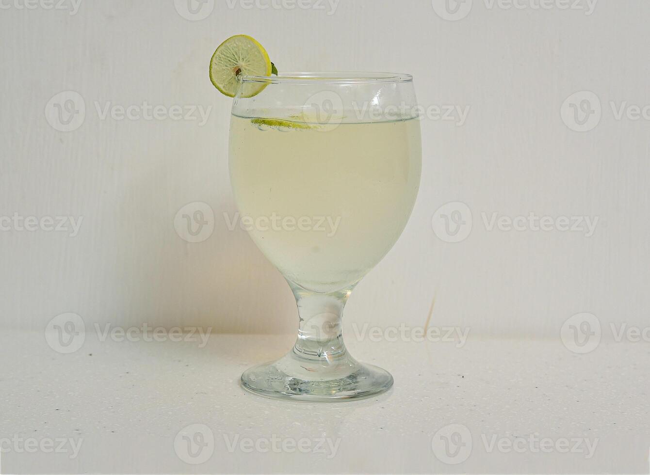 fresh lime water, lemo pani with lemon slice served in a glass isolated on grey background top view of indian, pakistani food photo