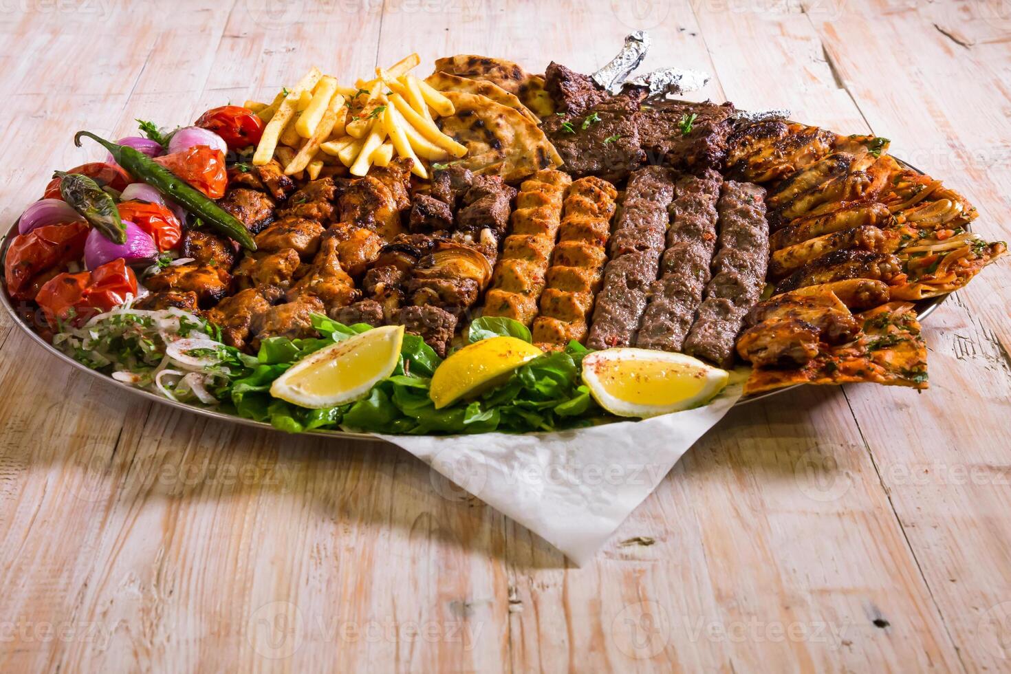 Assorted mix grills with chicken tikka, beef kabab, mutton kebab, wings, boti, malai, chop, shish tawook served in dish isolated on background top view of arabic food photo