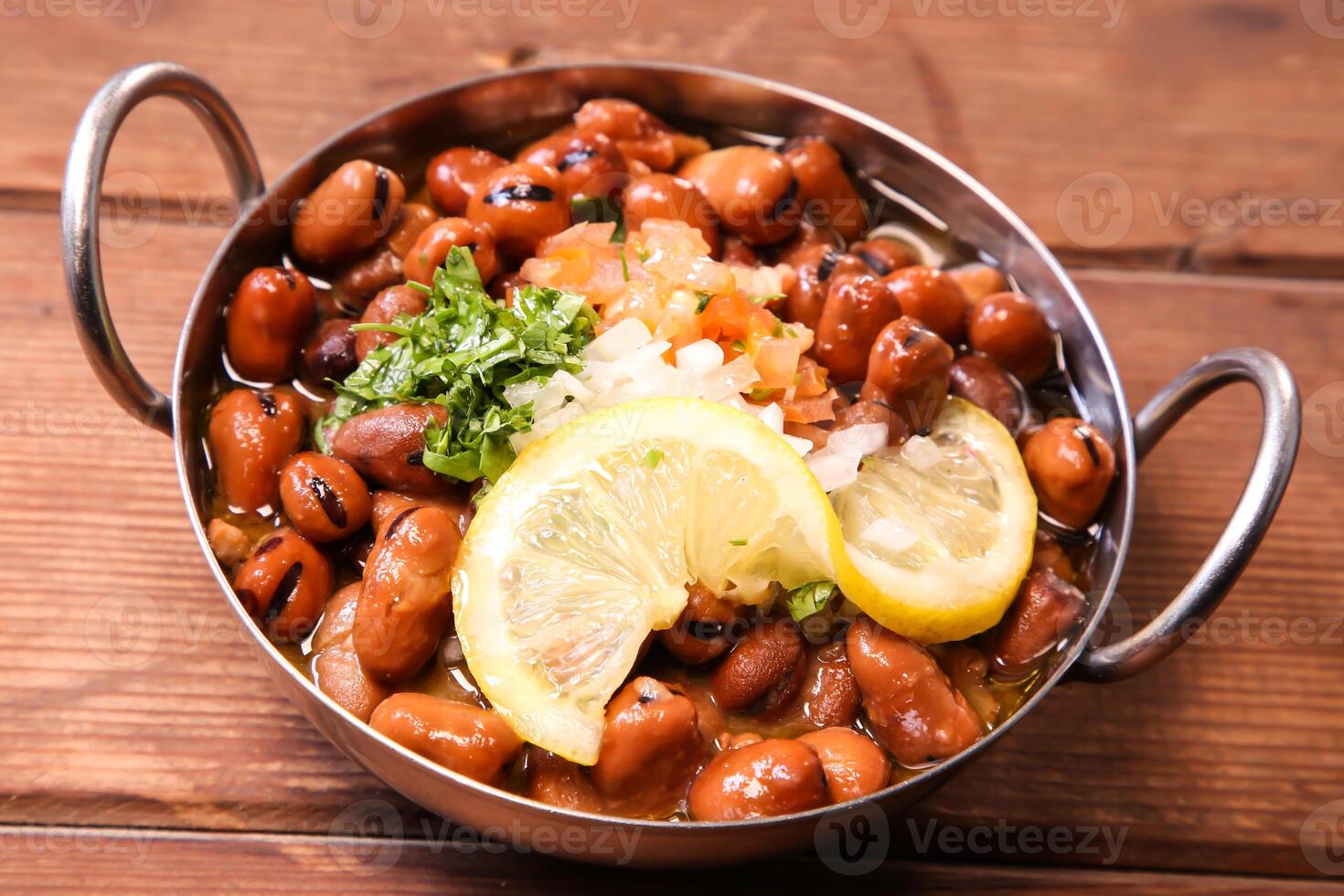 Lebanese Fool or foul with lemon, tomato, onion served in dish isolated on background top view of hot mezza photo