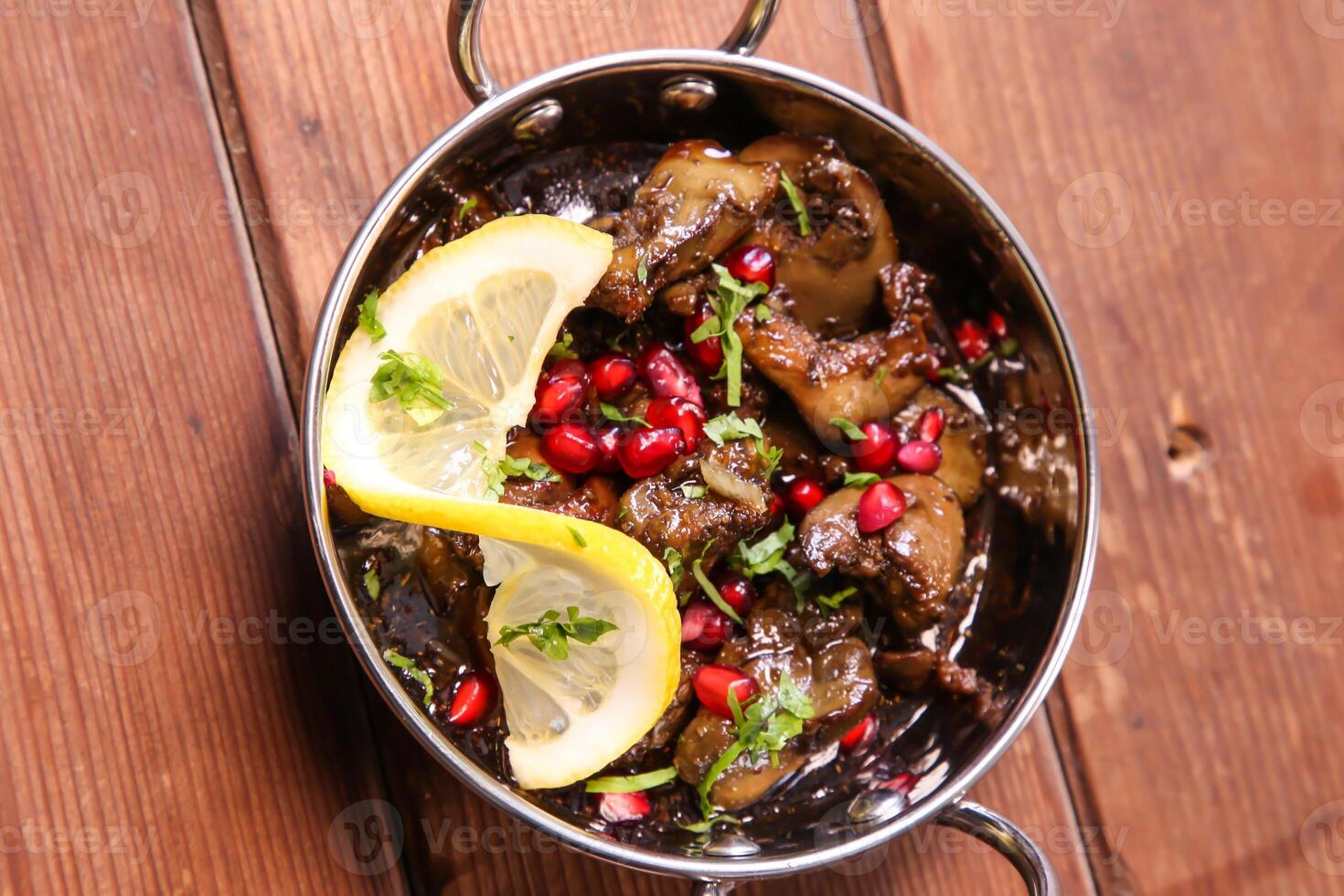 Spicy Chicken Liver with lime and pomegranate seeds served in dish isolated on background top view of hot mezza photo