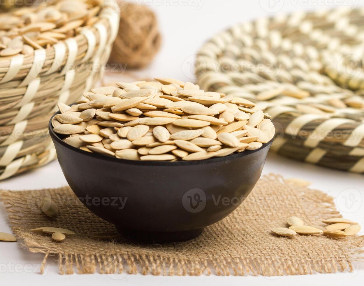 watermelon seeds served in a bowl isolated on napkin side view of nuts on grey backgroundwatermelon seeds served in a bowl isolated on napkin side view of nuts on grey background photo